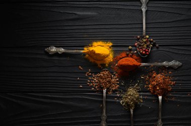 Colorful various herbs and spices for cooking on dark wooden rustic background