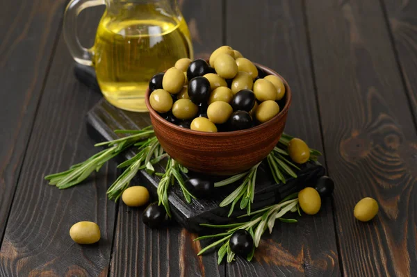 Black and green olives on a dark wooden rustic background.