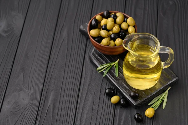 Black and green olives on a dark wooden black background.