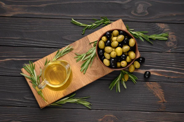 Black and green olives on a dark wooden rustic background.