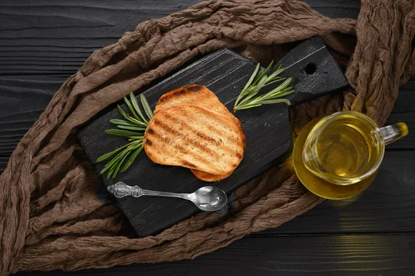 Sliced Toasted Bread Extra Virgin Olive Oil Rosemary Black Background — Stock Photo, Image