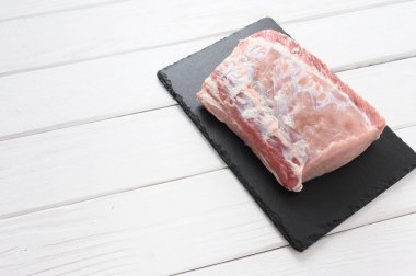 Beyaz arka planda büyük bir parça domuz filetosu..