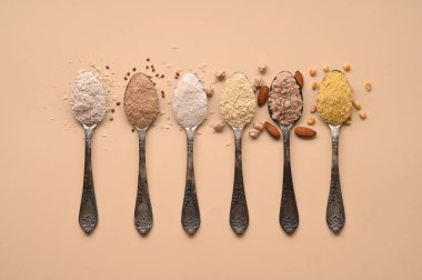 Gluten free text and spoons of various gluten free flour, almond buckwheat, rice, corn, oat, chickpea. Flat lay, top.
