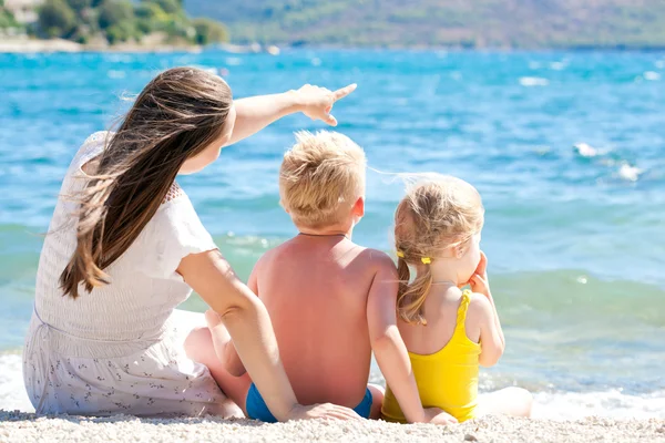 Mor med sine børn ved havet - Stock-foto