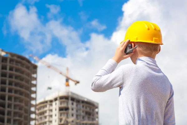 Jongen in een helm kijken naar gebouw — Stockfoto