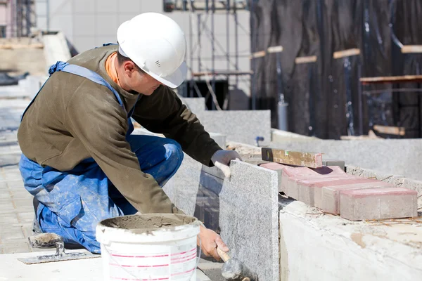 Fliesenleger verlegt Marmorfliesen auf Baustelle — Stockfoto