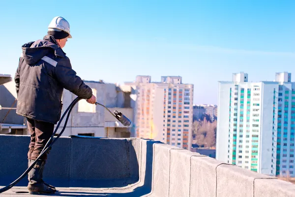 Εργαζόμενος roofer την εγκατάσταση υλικού κατασκευής σκεπής αισθητό — Φωτογραφία Αρχείου