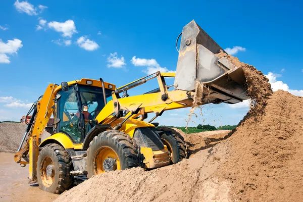 Máquina excavadora que descarga arena con agua Imágenes de stock libres de derechos