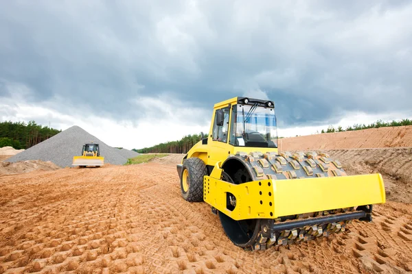 Rouleau de route et bulldozer pendant les travaux de construction — Photo