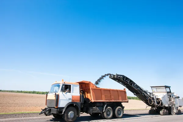 Planificator rece de încărcare de zdrobire asfalt în camion de gunoi — Fotografie, imagine de stoc