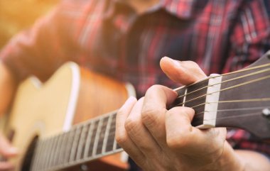 Musician playing acoustic guitar. Close up of man hand playing guitar.
