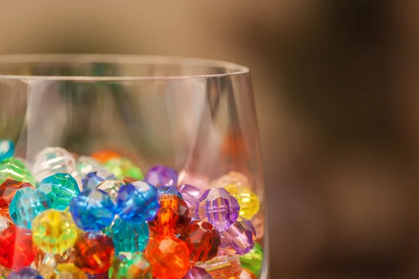 Plastikperlen im Weinglas — Stockfoto