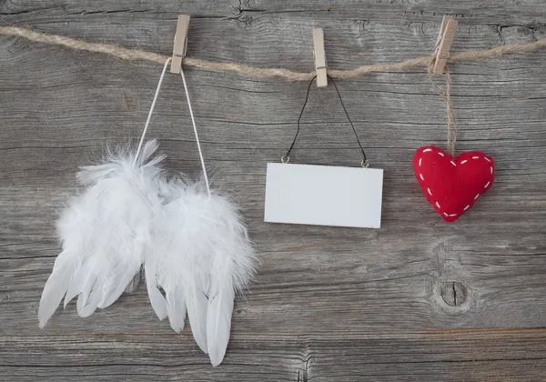 Asas de anjo com coração e nota em branco — Fotografia de Stock