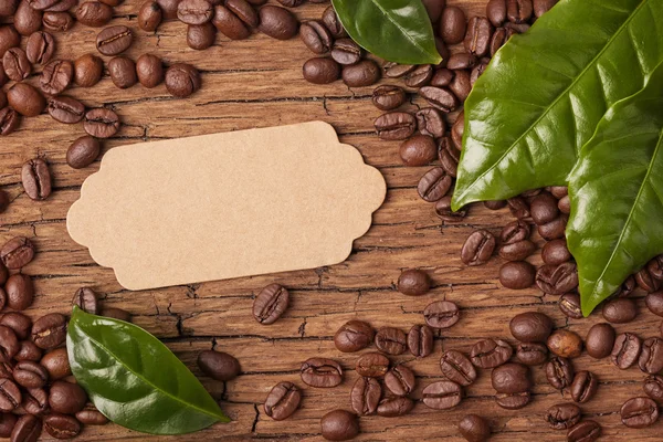 Granos de café y hojas verdes —  Fotos de Stock