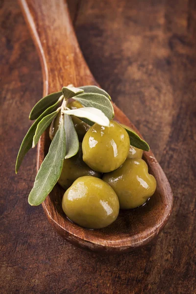 Löffel mit grünen Oliven — Stockfoto
