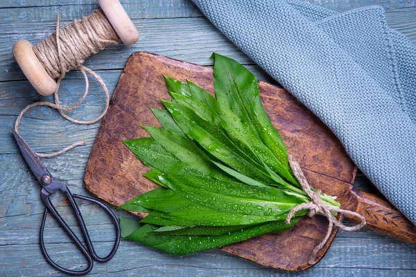 木制背景上的野生大蒜或羊毛脂绿叶 — 图库照片