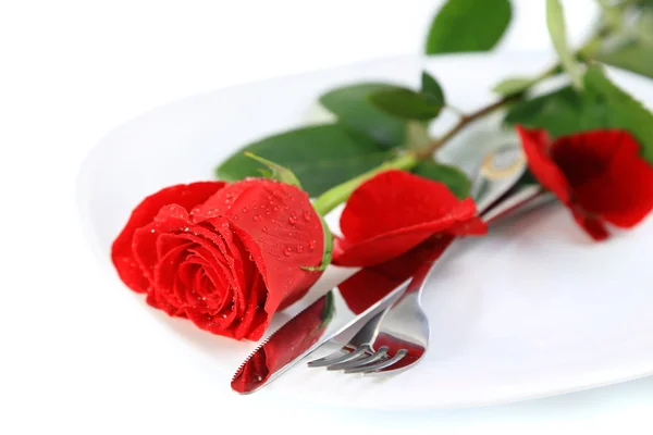 Closeup of red rose and cutlery on white plate — Stock Photo, Image