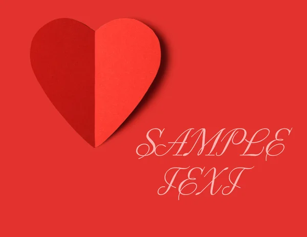 El corazón rojo de cartón sobre el fondo rojo — Foto de Stock