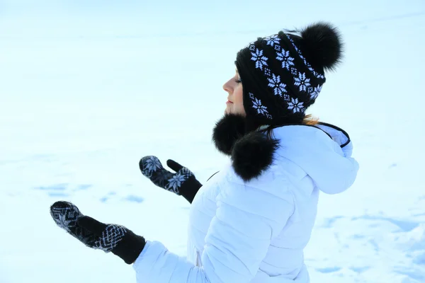 Schöne Frau in warmer Kleidung mit Schnee, fängt Schneeflocken — Stockfoto