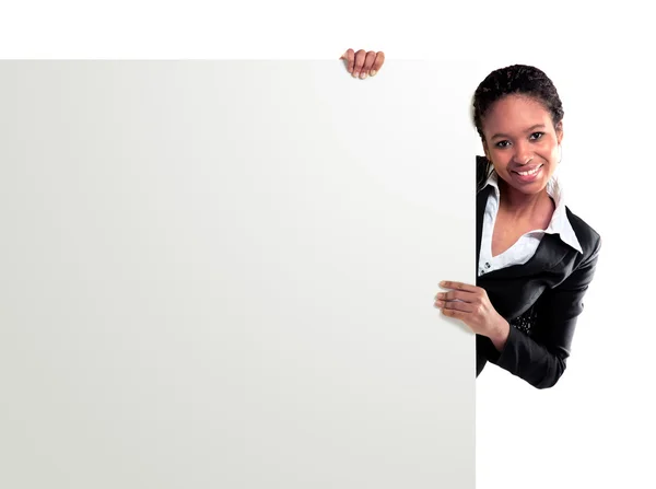 Female representative pointing towards placard and smiling at camera — Stock Photo, Image