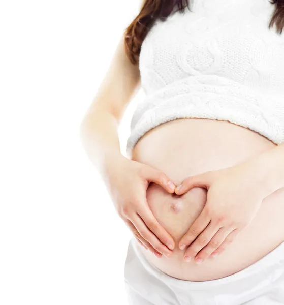 Zwangere vrouw vormen hart uit haar handen op haar baby bump. allemaal op witte achtergrond. — Stockfoto