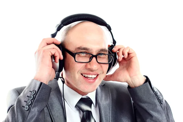 Homem de negócios sorrindo usando fones de ouvido olhando para a câmera, ouvindo música — Fotografia de Stock