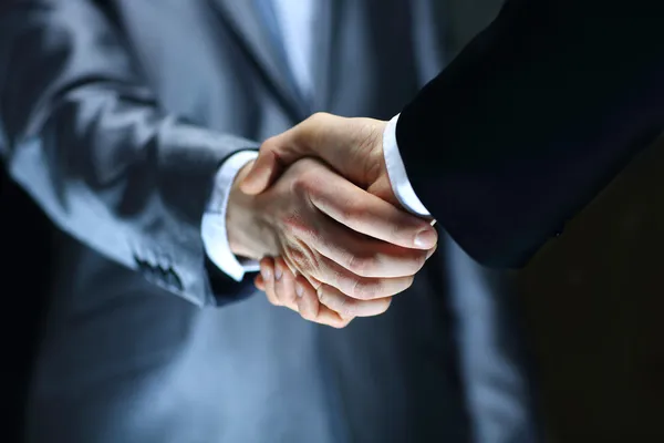 Handshake - Hand holding on black background — Stock Photo, Image