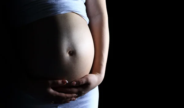 Hermosa mujer embarazada sobre fondo negro — Foto de Stock