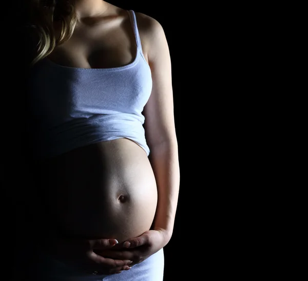 Hermosa mujer embarazada sobre fondo negro — Foto de Stock