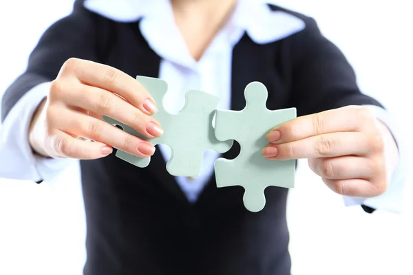 Geschäftsfrau zeigt zwei Puzzleteile. Konzept für Geschäftsstärke und Erfolg. — Stockfoto