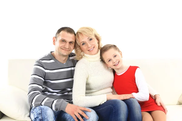 Gezin met twee kinderen zitten op witte lederen sofa — Stockfoto