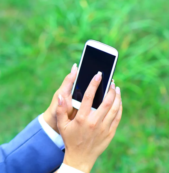 Žena pomocí mobilního telefonu v parku. — Stock fotografie