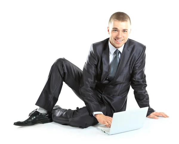 Gelukkig jonge business man aan het werk op een laptop, geïsoleerd op witte achtergrond — Stockfoto