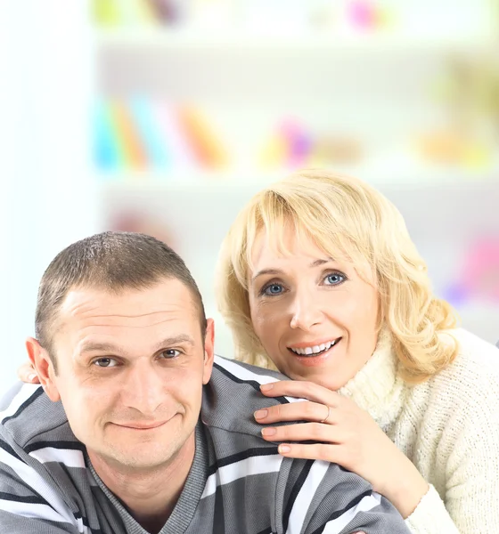 Casal feliz deitado no chão e sorrindo para a câmera isolada no fundo branco — Fotografia de Stock