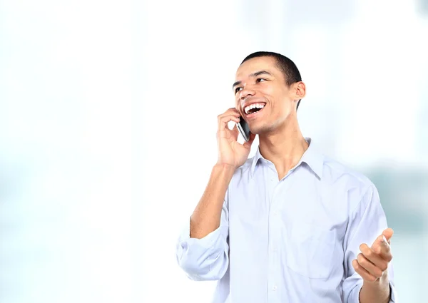 Успешный афроамериканский бизнесмен или мужчина разговаривает по мобильному телефону в современном офисе — стоковое фото
