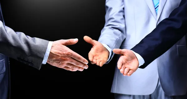 Twee zakenmannen schudden handen naar hun leider, close-up — Stockfoto