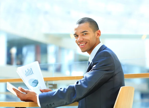 Porträtt av en glad afrikansk amerikansk entreprenör som visar datorn laptop på kontoret — Stockfoto