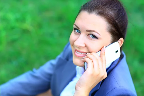 Porträtt av en ung affärskvinna utomhus talar på mobiltelefon — Stockfoto