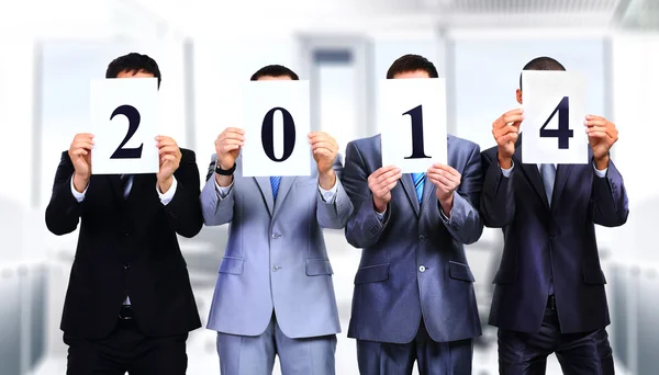 Colleagues holding 2014 signs in front of their faces — Stock Photo, Image