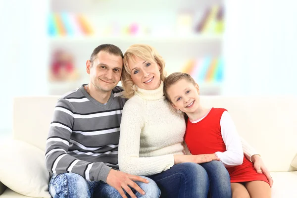Familie met meisje zit op witte lederen sofa — Stockfoto