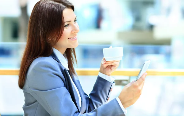 Café stad levensstijl vrouw op telefoon drinken koffie SMS-tekstbericht op smartphone app vergadering indoor in trendy stedelijke café — Stockfoto