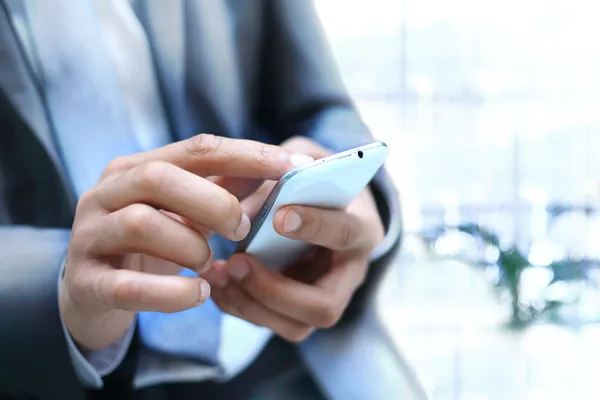 Primer plano de un hombre que usa un teléfono inteligente móvil — Foto de Stock