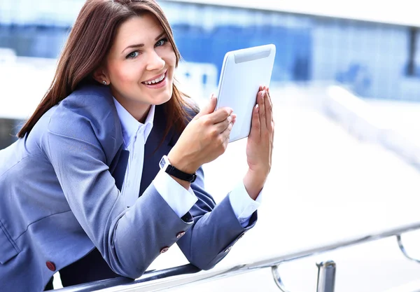 Bizneswoman pracuje na tablecie cyfrowym na zewnątrz nad tłem budynku — Zdjęcie stockowe