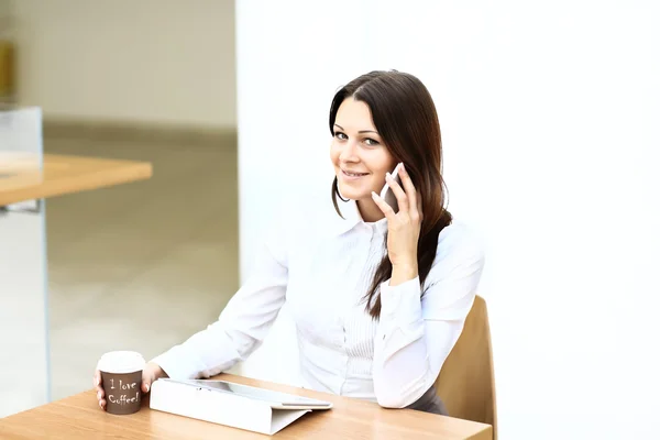 Feliz joven empresaria usando tableta en un café . — Foto de Stock