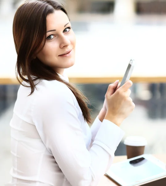 Feliz joven empresaria usando tableta en un café . — Foto de Stock