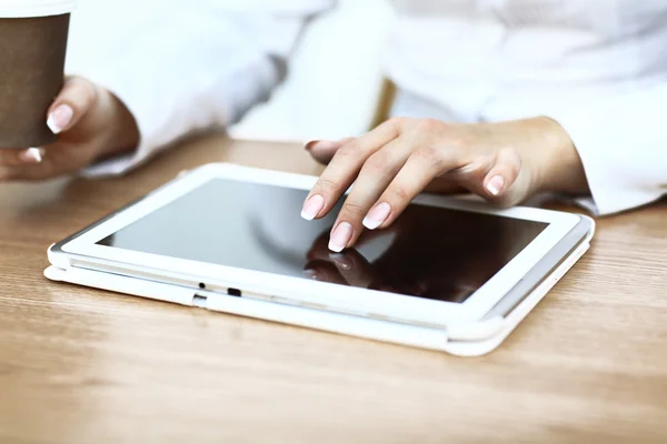 Weiße Tablette mit leerem Bildschirm in den Händen auf Holztisch — Stockfoto