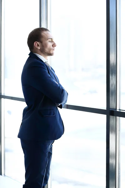 Composite image of thoughtful young businessman looking away — Stock Photo, Image