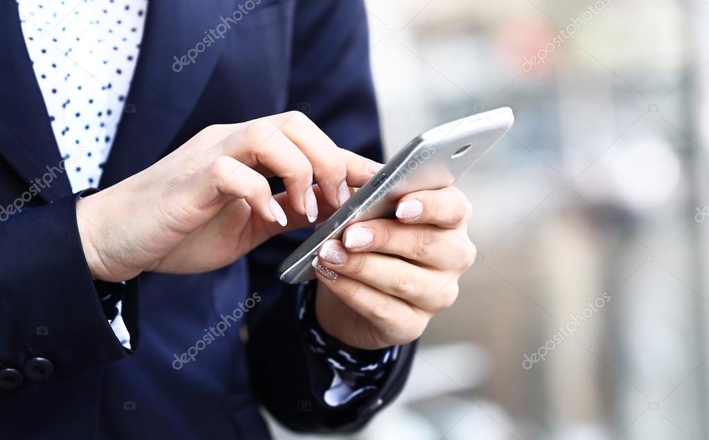 Close up of a business woman using mobile smart phone