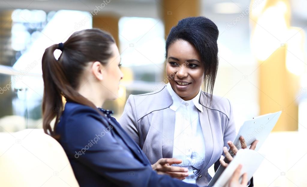 Businesswomen With Digital Tablet Sitting In Modern Office