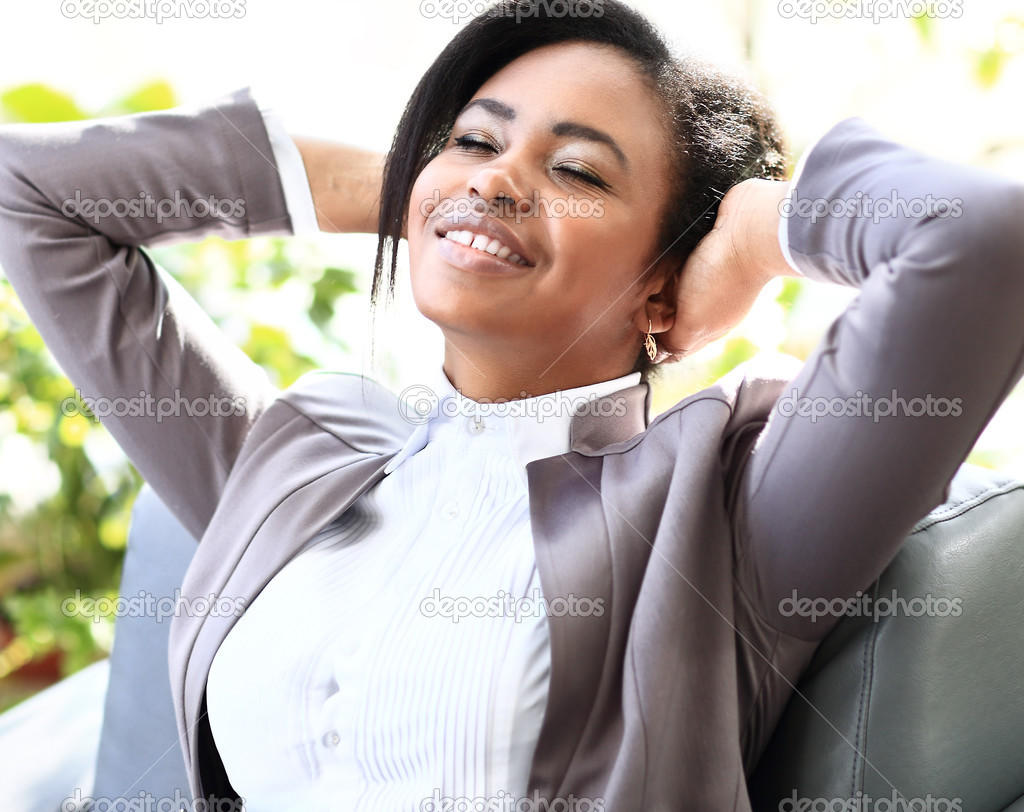 Happy young african american businesswoman relaxing in office